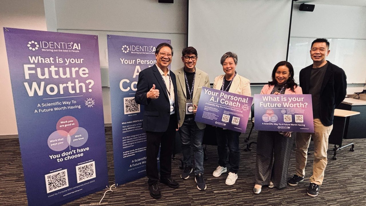 IDENTI3 team at the SUSS career fair beside personality profiling and AI coaching displays.